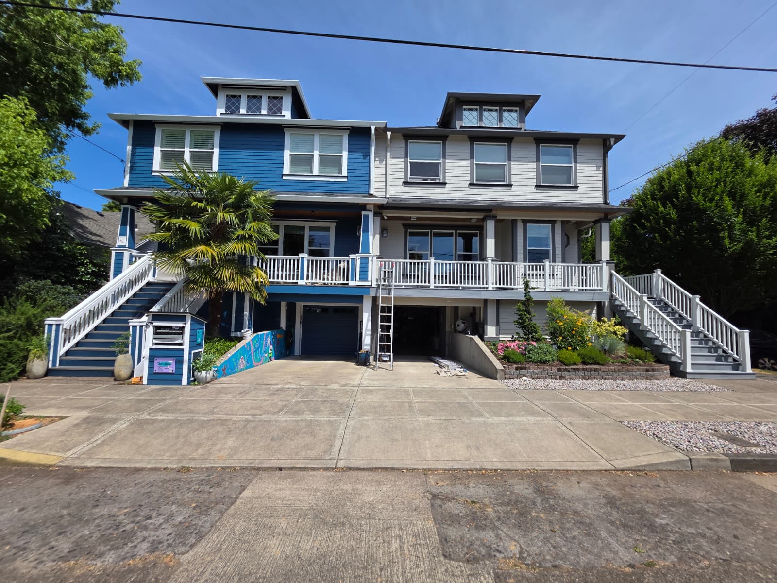 Completed exterior repaint of a multi-unit home in deep blue and warm gray tones